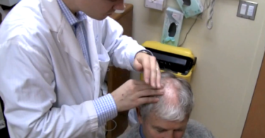 Doctor examines man's head