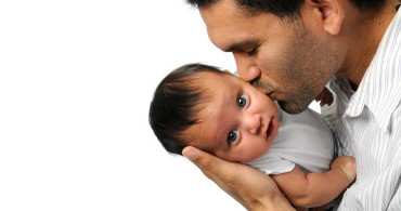 Dad kissing his baby