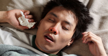 A man sick in bed with the flu