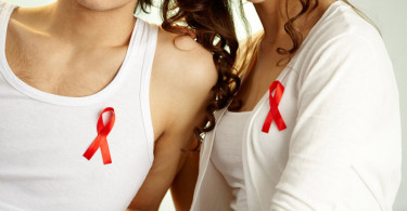 A couple wearing the red HIV/AIDS ribbon