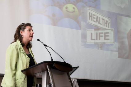 Woman speaks at podium about 30x30 challenge