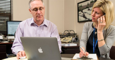 Dr. Anthony Levitt and Naomi Algate sit in office together