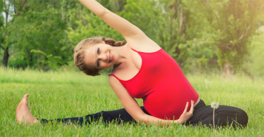 Pregnant woman doing yoga in a park