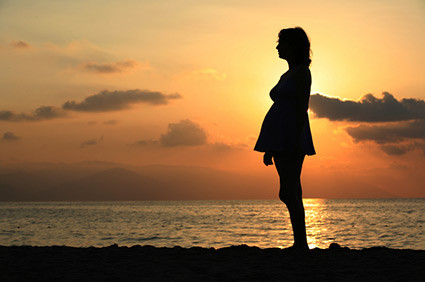 silhouette of pregnant woman in sunset