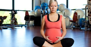 A pregnant woman sitting in a gym