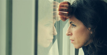 Upset woman looking outside of window