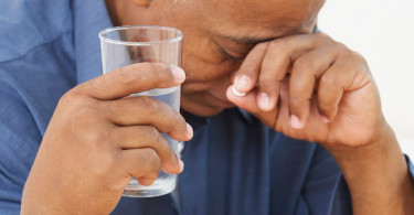 Man holding glass of liquid
