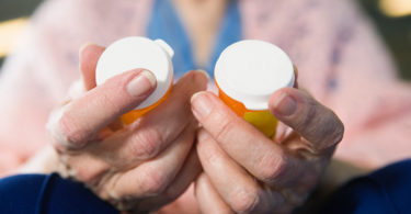 Elderly holding medication bottles