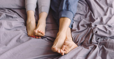 a couple's feet in a bed