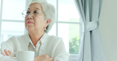 Senior woman sitting alone with a coffee