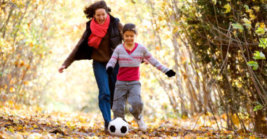Family playing soccer outside