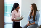 Female doctor speaking with young woman patient