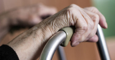 Elderly hands and a walker