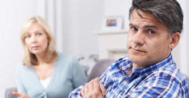 man and woman arguing on couch