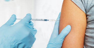close up of needle near upper arm