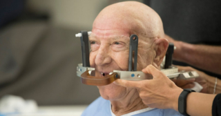 Patient gets fitted with helmet for focused ultrasound procedure