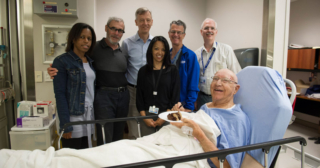 Patient and care team celebrate the 100th focused ultrasound treatment for essential tremor with cake!
