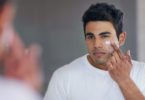 man applying moisturizer to face