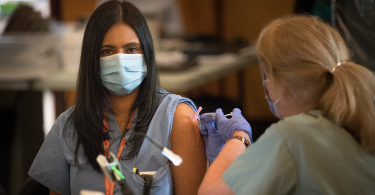 health-care worker gets their COVID-19 vaccine