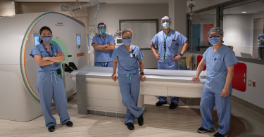 Protected Code Stroke team poses for a photo beside an imaging device