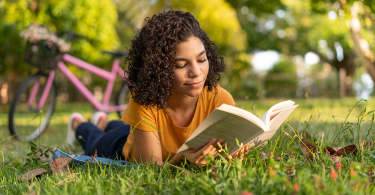 Youth reading a book outside