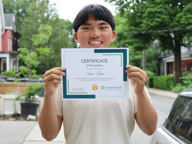 Student Sean Chen displays certificate recognizing his leadership in the field of injury prevention