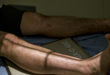 Image of male legs on hospital bed.
